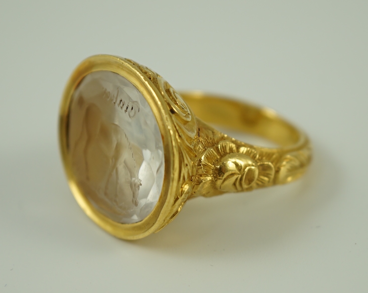 A large antique style gold and intaglio white stone set ring